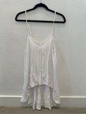 LJC Designs white tank top features a high-low hem and delicate spaghetti straps